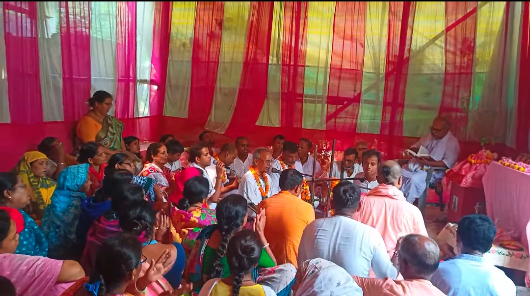 Group of devotees joyfully participating in Kirtan with traditional instruments